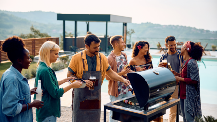 Symbolbild private Haftpflichtversicherung zeigt feiernde Menschen um einen Grill