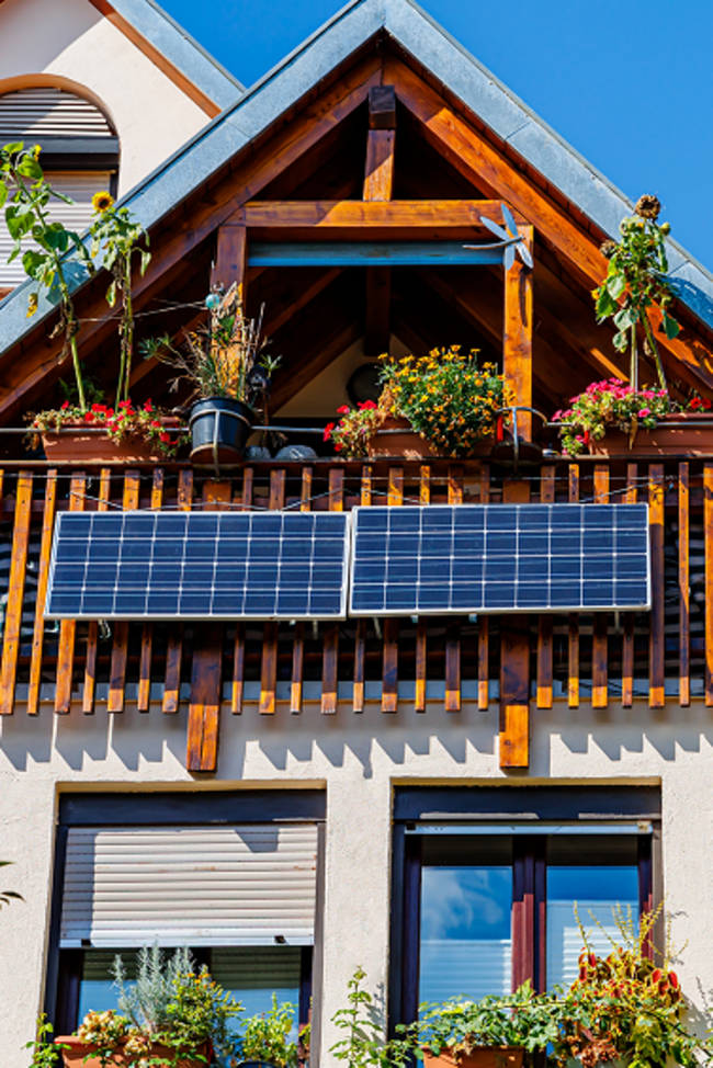 Bild zeigt Einfamilienhaus mit Giebeldach und PV-Anlage auf der Balkonbrüstung